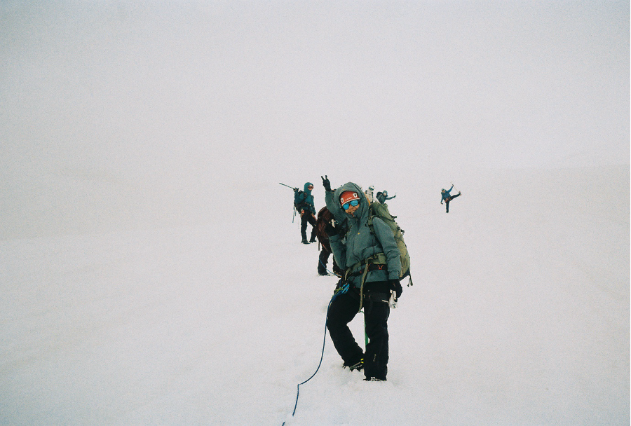 Climbers moving together in a rope team through whiteout conditions